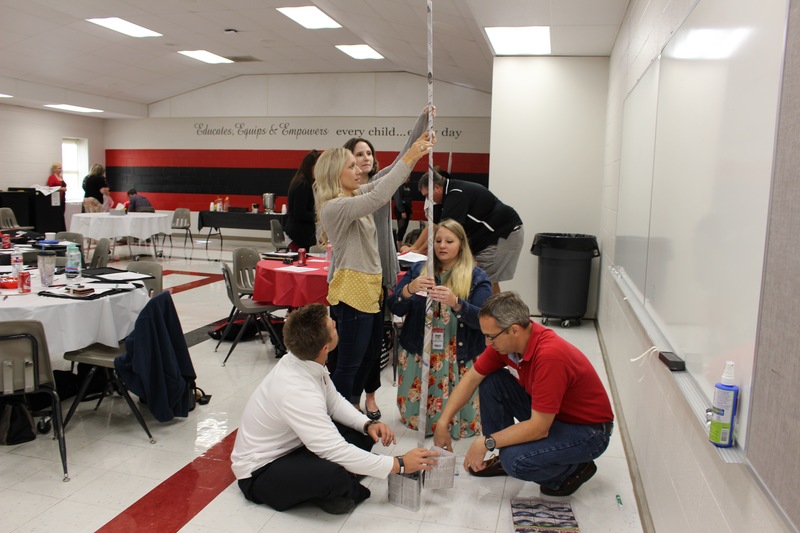 New teachers work on a paper rock during new teacher academy.